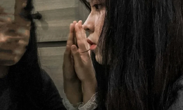 امرأة تشعر بالقلق عند النظر إلى المرآة بسبب فوبيا المرايا